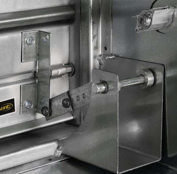 Close-up of a Series 30 Fire and Smoke Dampers Class I assembly by Aire Technologies, featuring metal brackets, a hinge, and cylindrical parts—commonly used in UL 555 applications—mounted on a metallic surface.
