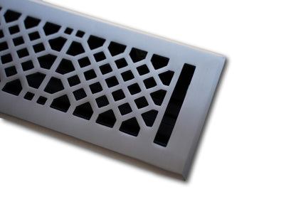 A close-up of the Madelyn Carter Cast Brass Vintage Industrial Vent Cover in brushed nickel, showcasing its geometric cutout pattern against a white background.