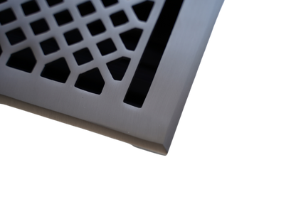 Close-up of the Madelyn Carter Cast Brass Vintage Industrial Vent Cover in brushed nickel, featuring a geometric cutout pattern against a white background.