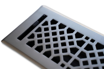 A close-up of the Madelyn Carter Cast Brass Vintage Industrial Vent Cover in Brushed Nickel, featuring a geometric cutout pattern and an adjustable airflow lever.