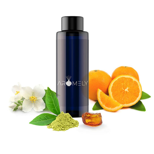 A dark blue AROMELY "Amber Oasis - Inspired by: The Delano®" bottle is displayed with white flowers, green leaves, matcha powder, amber resin, and oranges—perfect for scenting diffusers with a refreshing green tea fragrance.