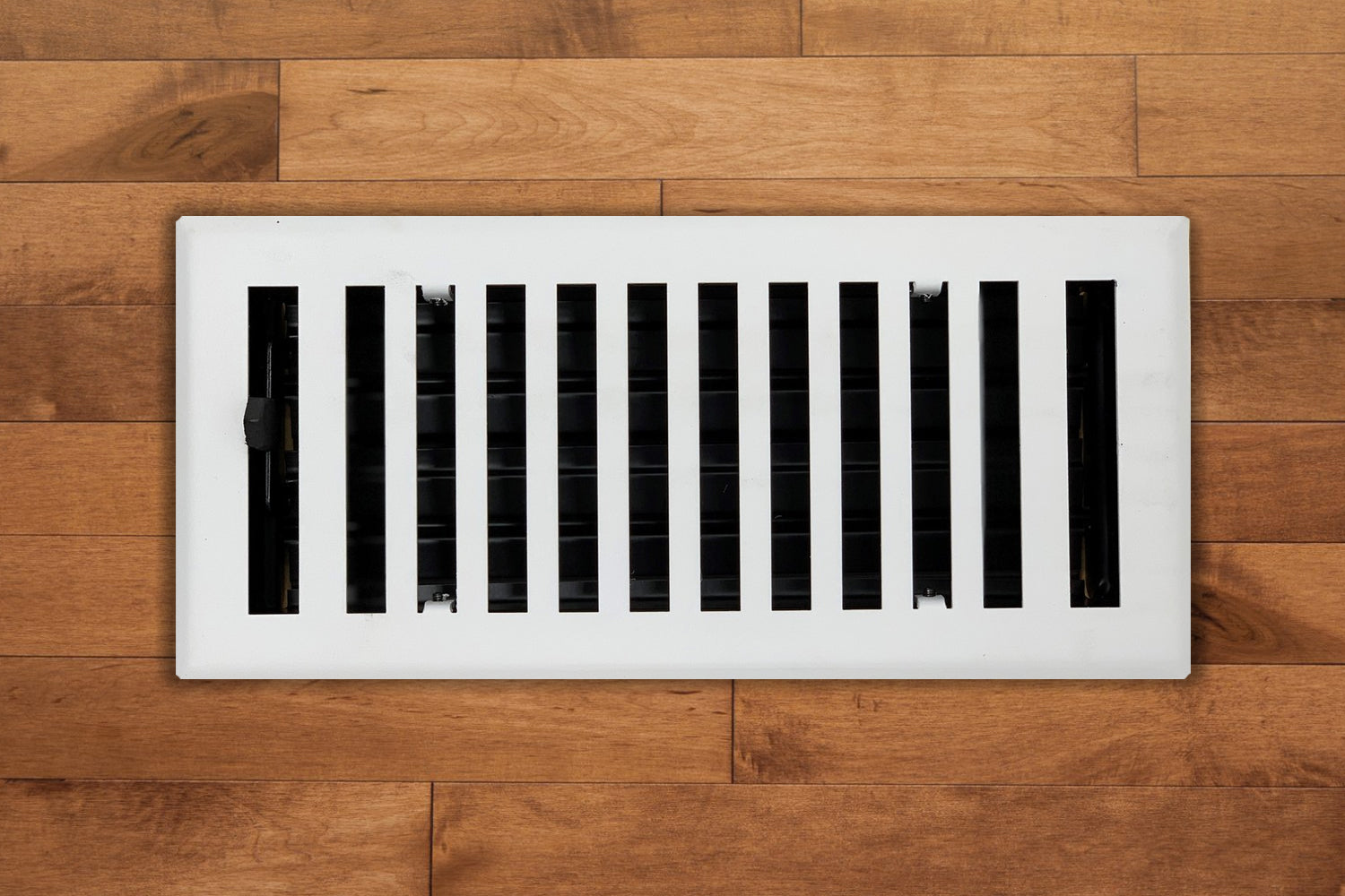 The Madelyn Carter Steel Modern Chic Vent Covers in white feature vertical slats that add a stylish touch to light brown wooden floors.
