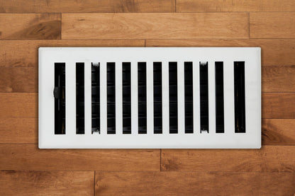 The Madelyn Carter Steel Modern Chic Vent Covers in white feature vertical slats that add a stylish touch to light brown wooden floors.