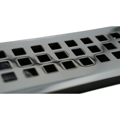 Close-up of a Madelyn Carter Cast Brass Artisan Vent Cover in Polished Chrome, featuring precision detailing and square holes arranged in rows on its metallic surface.