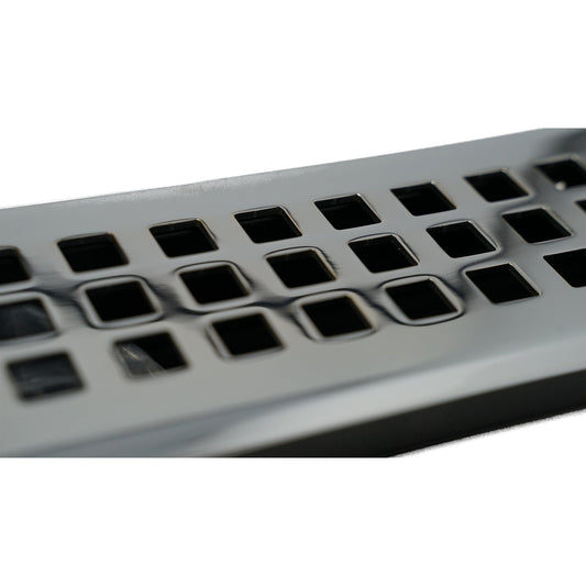 Close-up of a Madelyn Carter Cast Brass Artisan Vent Cover in Polished Chrome, featuring precision detailing and square holes arranged in rows on its metallic surface.