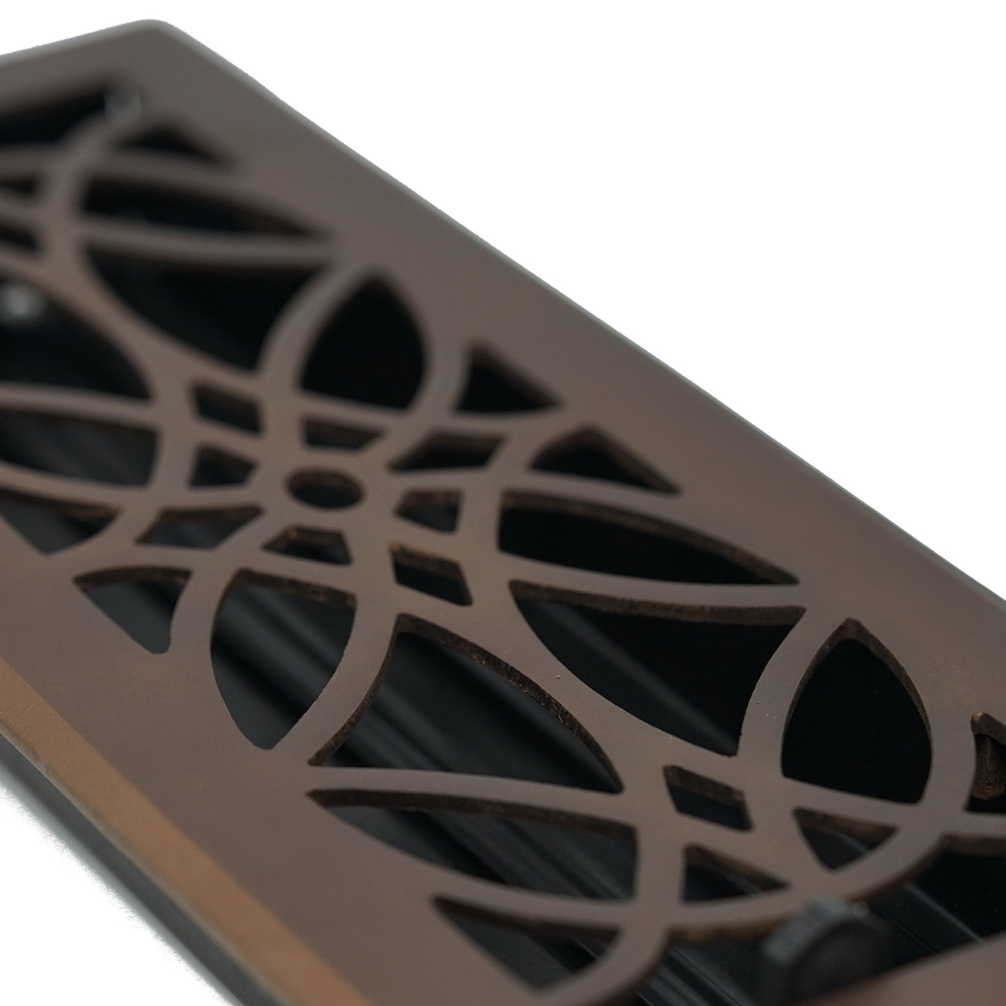 A close-up of the Madelyn Carter Cast Brass Empire Vent Cover highlights its geometric floral cutouts and luxurious oil rubbed bronze finish.