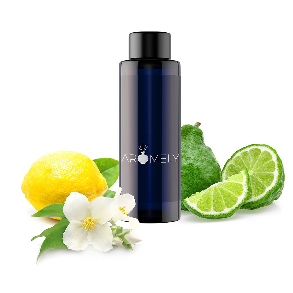 A dark blue AROMELY "Ocean Breeze - Inspired by: Ritz Carlton®" bottle sits among lemon, bergamot, lime slices, and a white flower on a white background, evoking an oceanic scent in this essential oil blend.